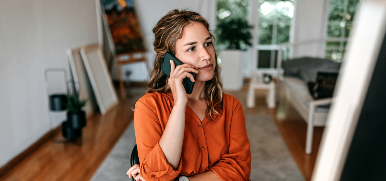 Person standing in a room, talking on a mobile phone