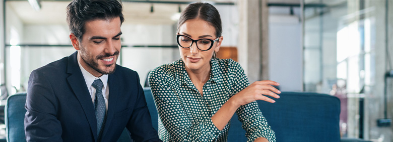 Two professionals sitting and looking down at something in front of them.
